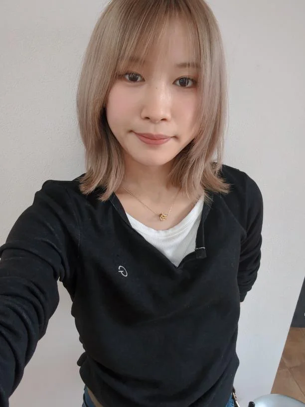 自然な表情で立つ女性スタイリストのポートレート