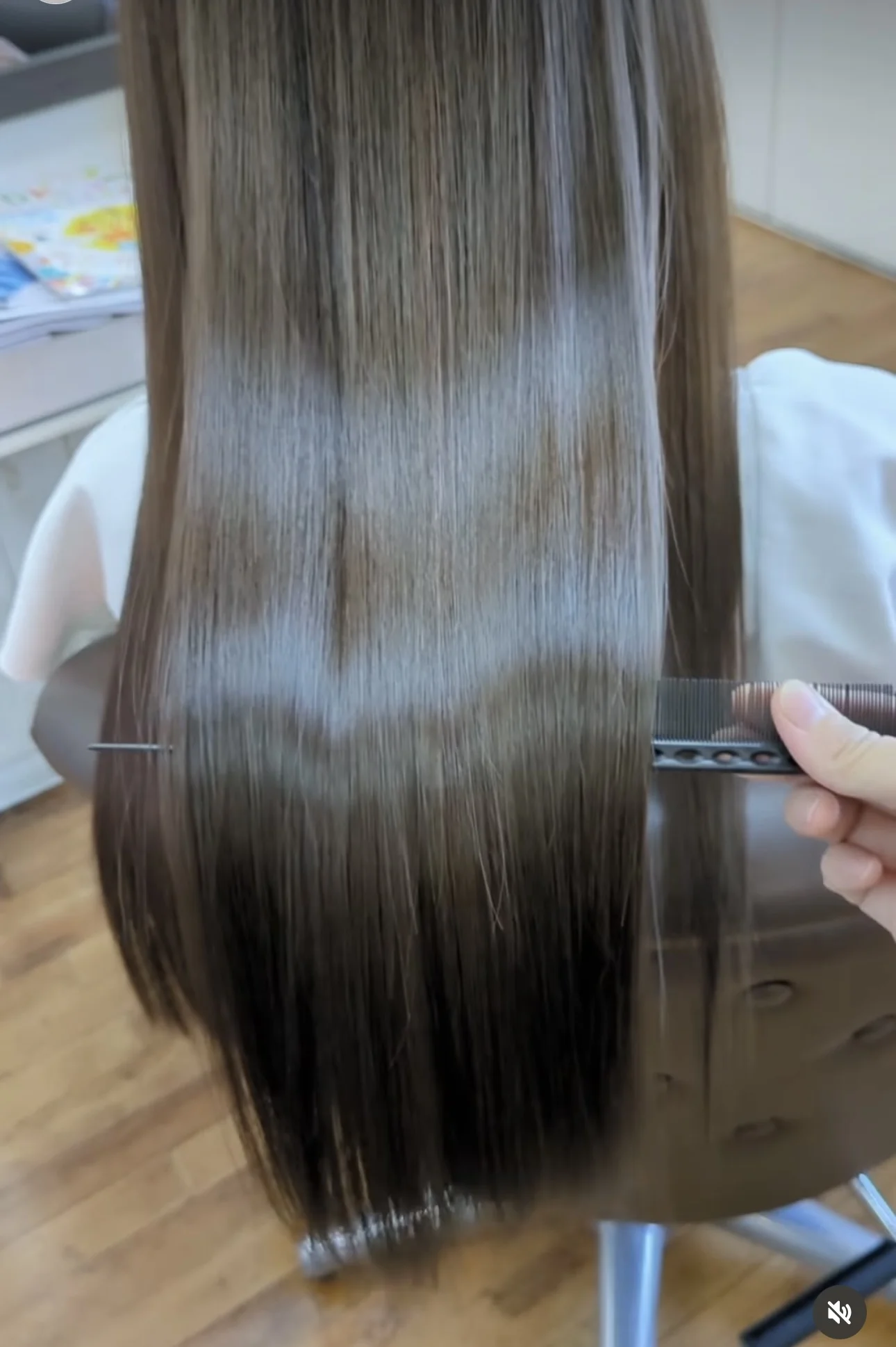 ロングヘアを手で整えながら毛先の状態を確認する様子