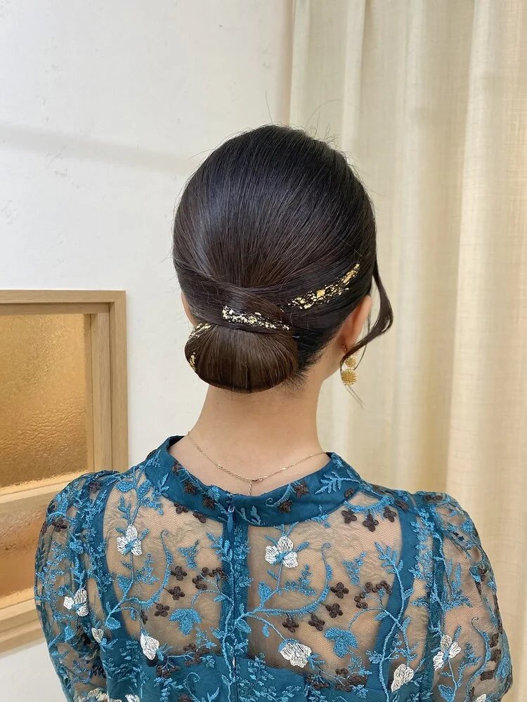 ロングヘアにトリートメントをなじませながら手入れをする後ろ姿